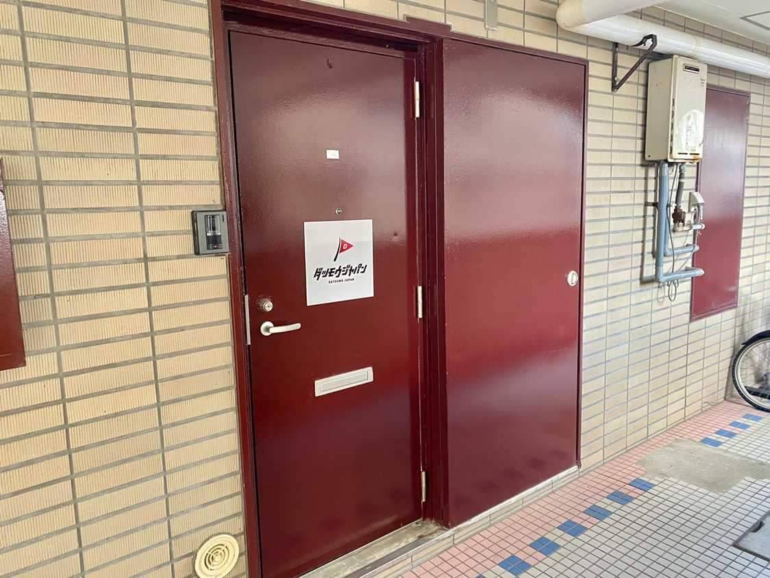 下関店入口のロゴがある赤いドア